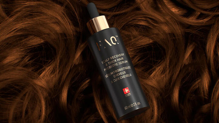 FAQ™ Scalp Recovery & Thick Hair Probiotic Serum on a bed of soft, strong curls